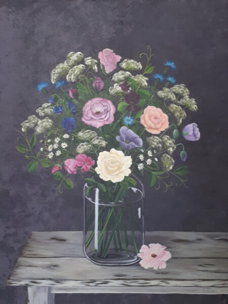 The Sweet Scents Of Summer flowers arranged in a glass vase, roses, sweet peas, on a vintage table